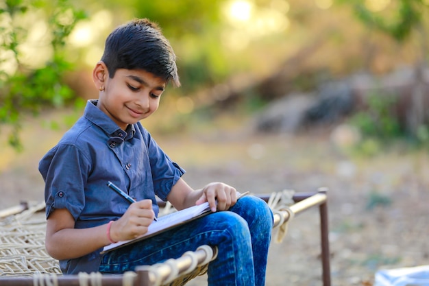 Cute indian child doing his homework at home