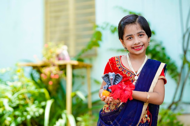 Cute indian little girl celebrating lord ganesha festival