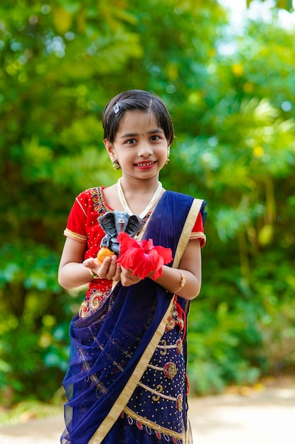 Cute indian little girl celebrating lord ganesha festival