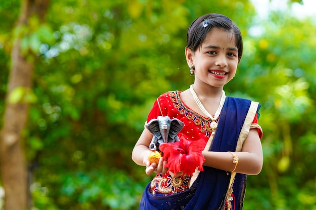 Cute indian little girl celebrating lord ganesha festival