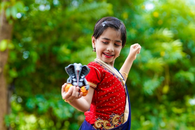 Cute indian little girl celebrating lord ganesha festival