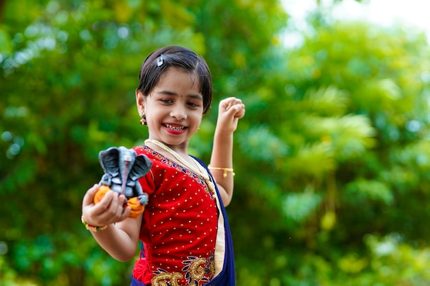 Cute indian little girl celebrating lord ganesha festival