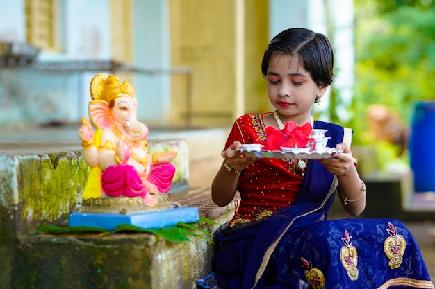 Cute indian little girl celebrating lord ganesha festival