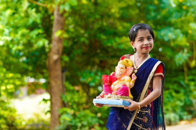 Cute indian little girl celebrating lord ganesha festival