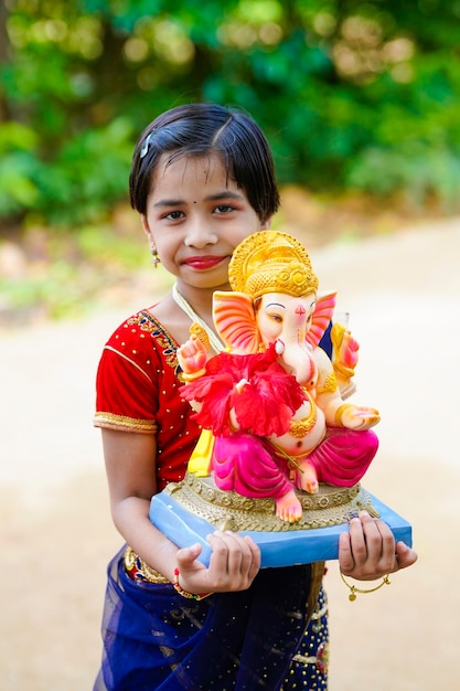 Cute indian little girl celebrating lord ganesha festival