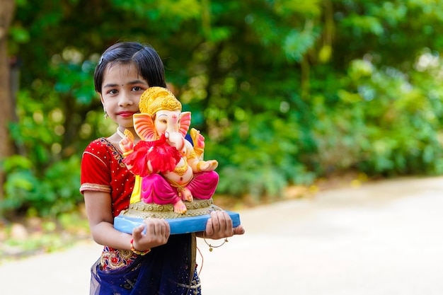 Cute indian little girl celebrating lord ganesha festival