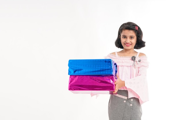 Cute indian little girl Child with gifts boxes in traditional cloths standing isolated over white background