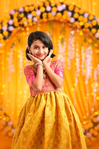 Cute indian little girl giving expression on colorful background