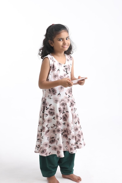 Cute indian little girl using smartphone on white background