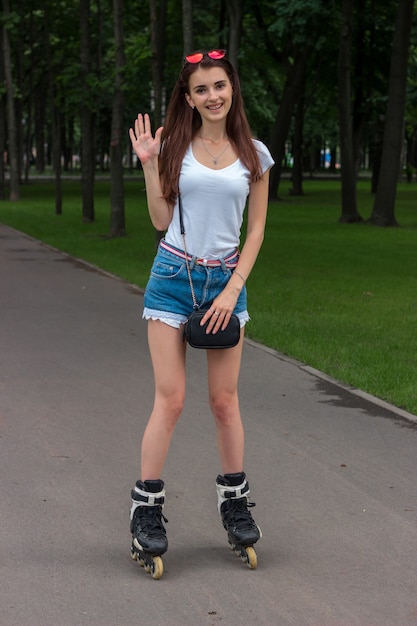 Cute joyful woman stands on the roller arm waving and smiling