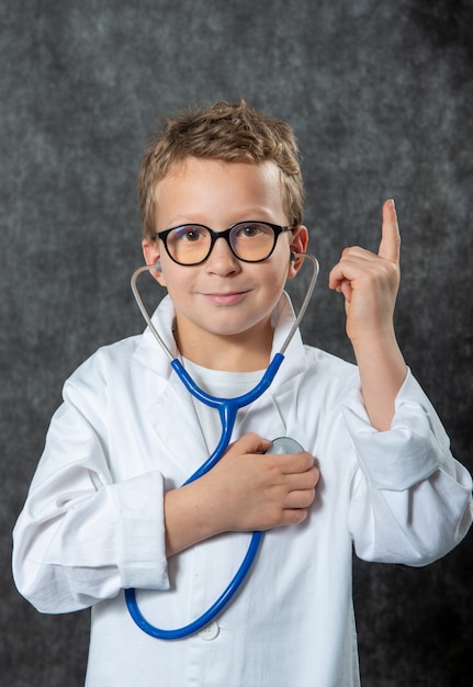 Cute kid boy wear medical uniform playing doctor, portrait