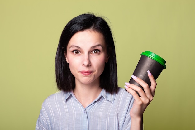 cute lady holds a cup of coffee in her hands green background