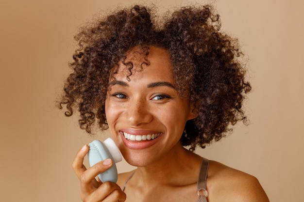 Cute lady using cosmetic tool in studio