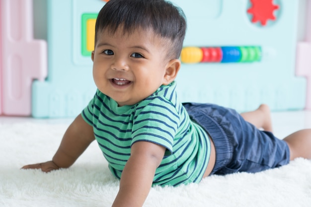 Cute lillte boy lying on soft blanket and smiling 