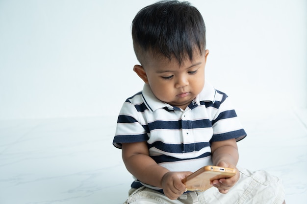 Cute little asian baby boy play smart phone