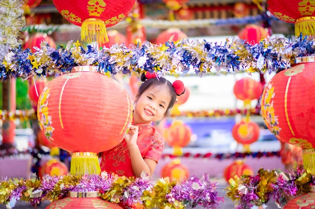 Cute little asian girl in chinese traditional dress smiling in the temple.Happy chinese new year concept.