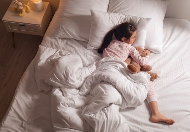 Cute little Asian girl sleeping in bed