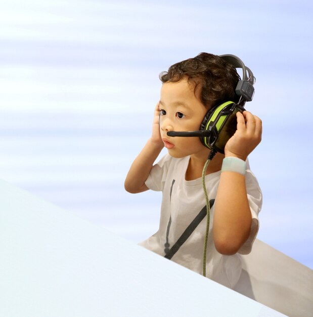 Cute little asian one boy wearing headphone listening amazing music or excited entertainment