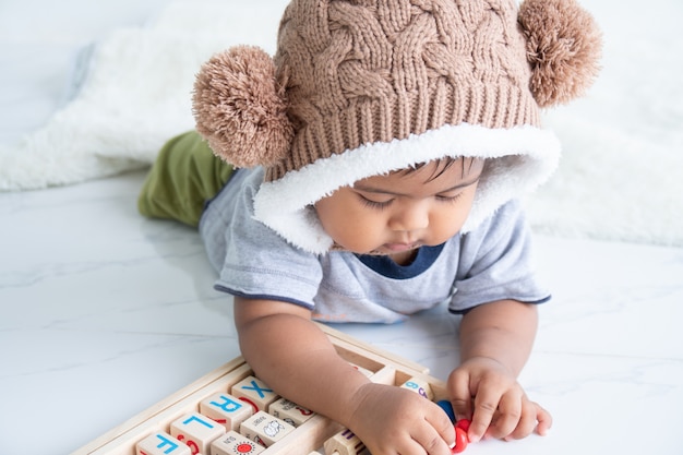 Cute little asin baby boy playing with wooden toy