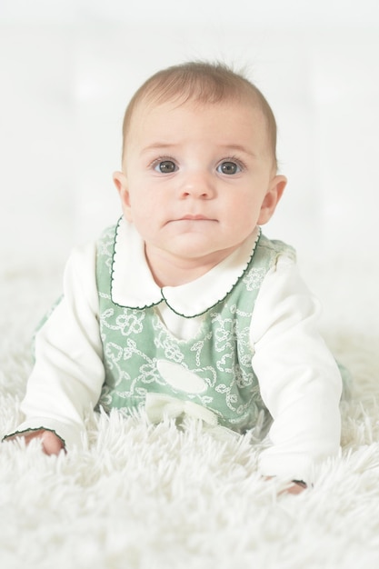 Cute little baby girl on white blanket