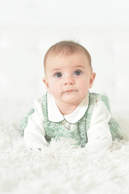 Cute little baby girl on white blanket