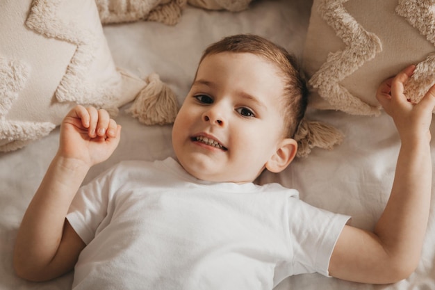 Cute little baby lies on the bed top view portrait of a boy in bed