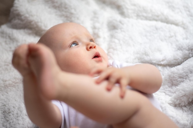 Cute little baby lies on a white blanket