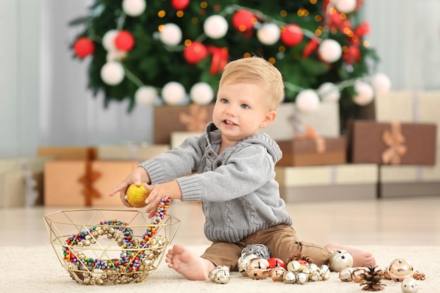 Cute little baby playing with Christmas decor at home