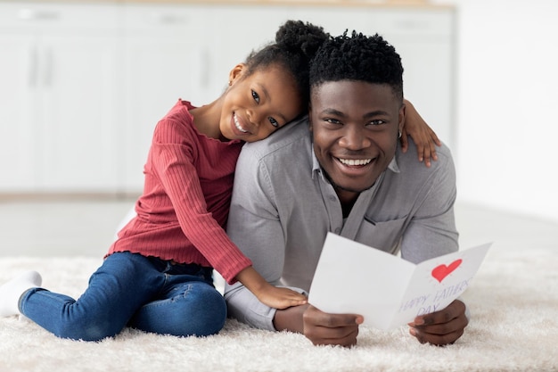 Cute little black girl greeting her dad with fathers day