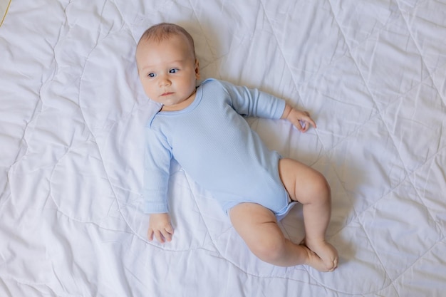 cute little boy in blue body laying on blanket, card, banner, health, space for text