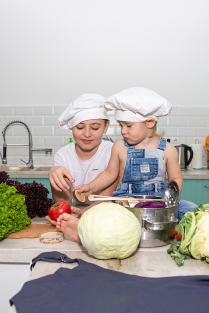 A cute little boy in a chefs costume cooks food with emotions