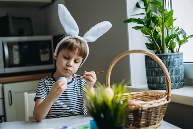 Cute little boy colouring eggs for easter