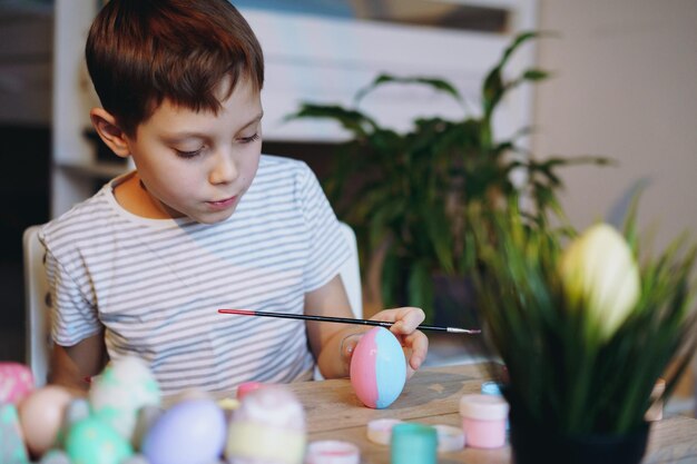 Cute little boy colouring eggs for easter