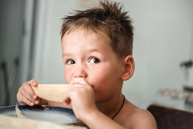 Cute little boy eating a slice of fresh melon