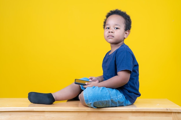 Cute little boy learning internet or playing games with tablet