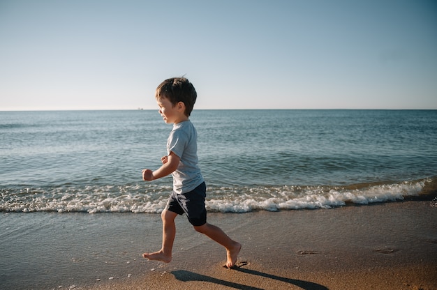 Cute little boy playing on the seashore