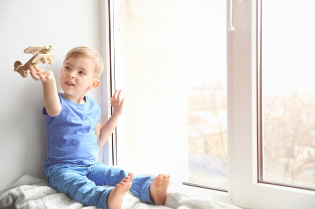 Cute little boy playing on windowsill