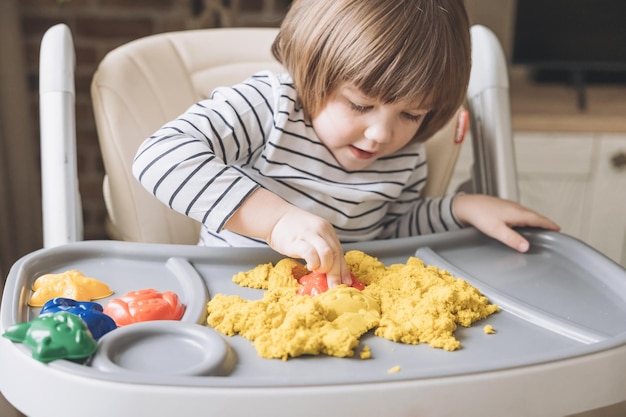 Cute little boy playing with kinetic sand Development of fine motor skills Early sensory education Hands of child moulding with magic kinetic sand Sand art therapy Activities Montessori