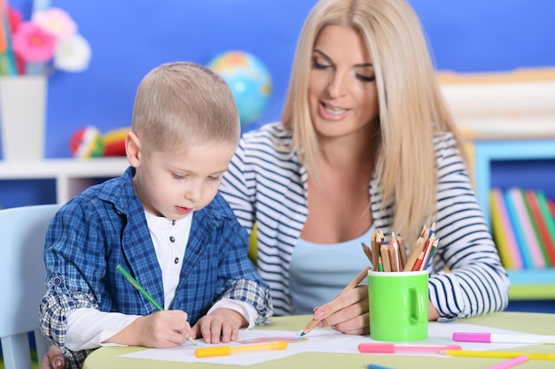 Cute little boy playing with mother at home or kindergarten