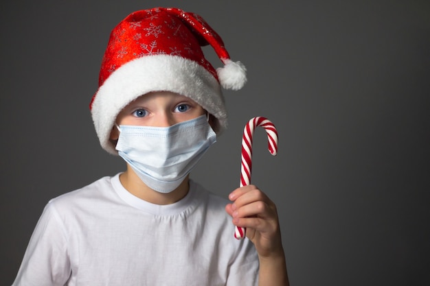 Cute little boy in Santa hat with a protective mask