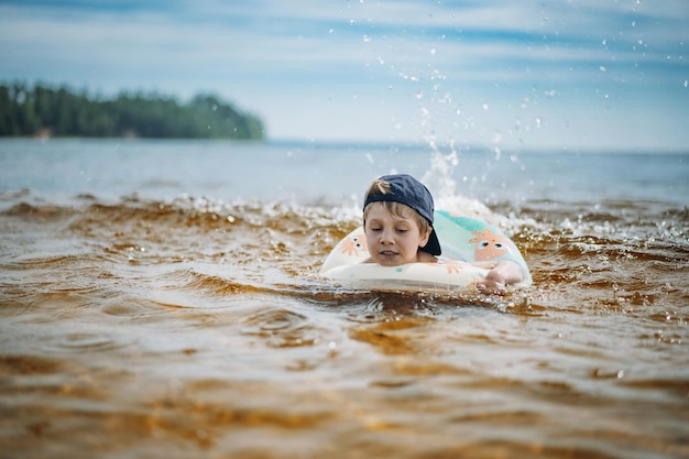 Cute little boy swimming in sea on rubber ring