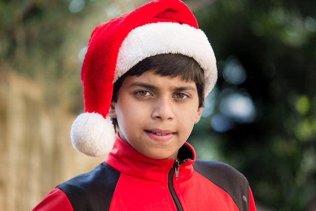 A cute little boy with Santa cap red tshirt smiling happily during Christmas time