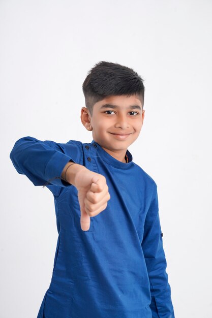 Cute little boy with thump down gesture on white background