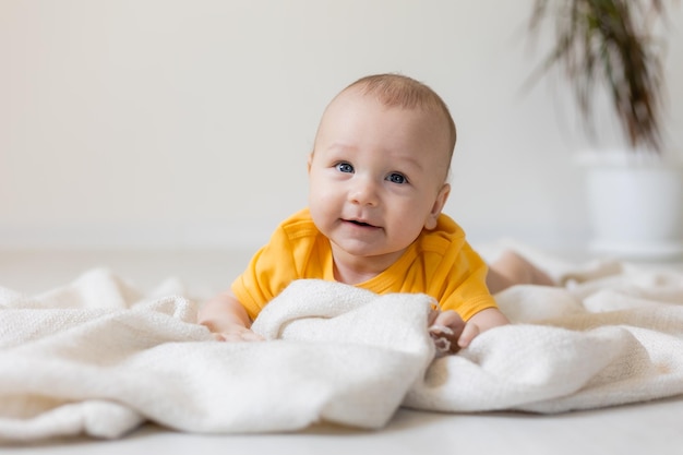 cute little boy in yellow body laying on blanket, card, banner, health, space for text