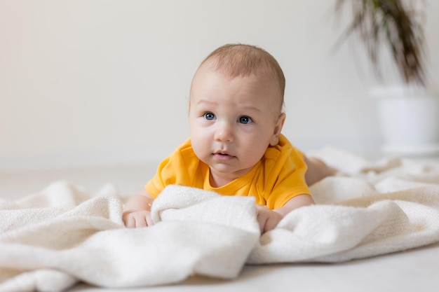 cute little boy in yellow body laying on blanket, card, banner, health, space for text