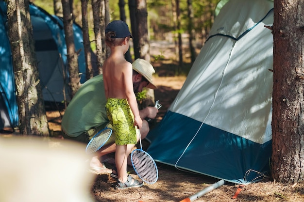 Cute little caucasian boy helping to put up a tent Family camping concept