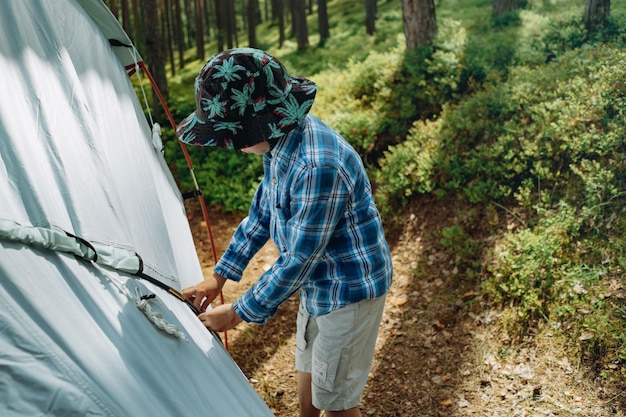 Cute little caucasian boy putting up a tent Family camping concept