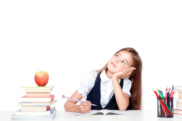 Cute little child girl looking up on the desk at school.