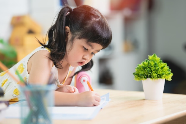 Cute little child painting with colorful paints Asian girl using wood color drawing colorBaby artist activity lifestyle concept