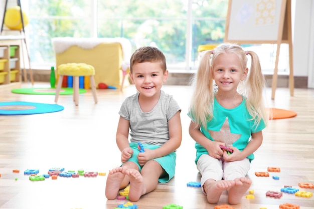 Cute little children playing with math puzzle at home